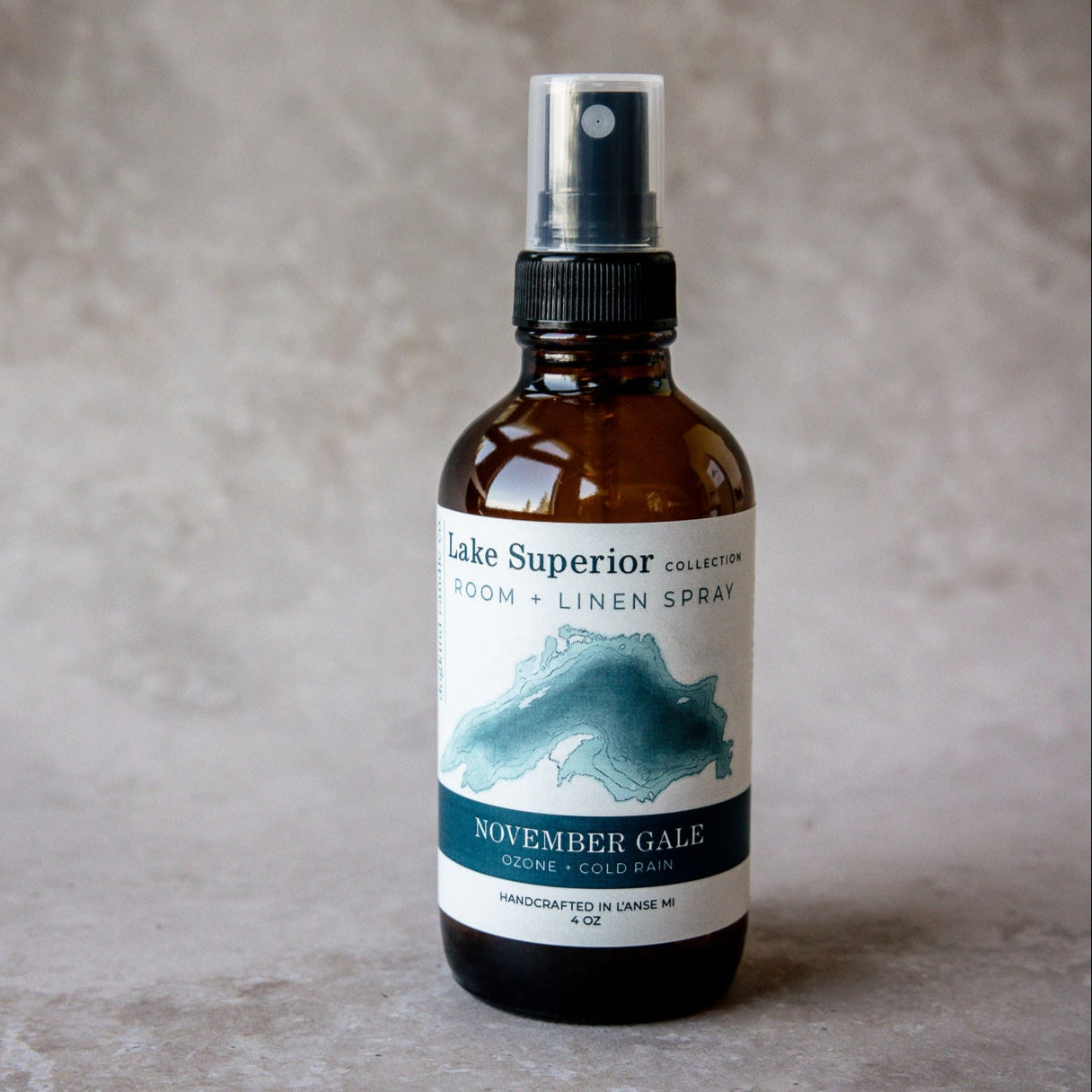 
                  
                    Bottle of Lakee Superior Room & Linen Spray november gale ozone and cold rain scent on a textured surface
                  
                