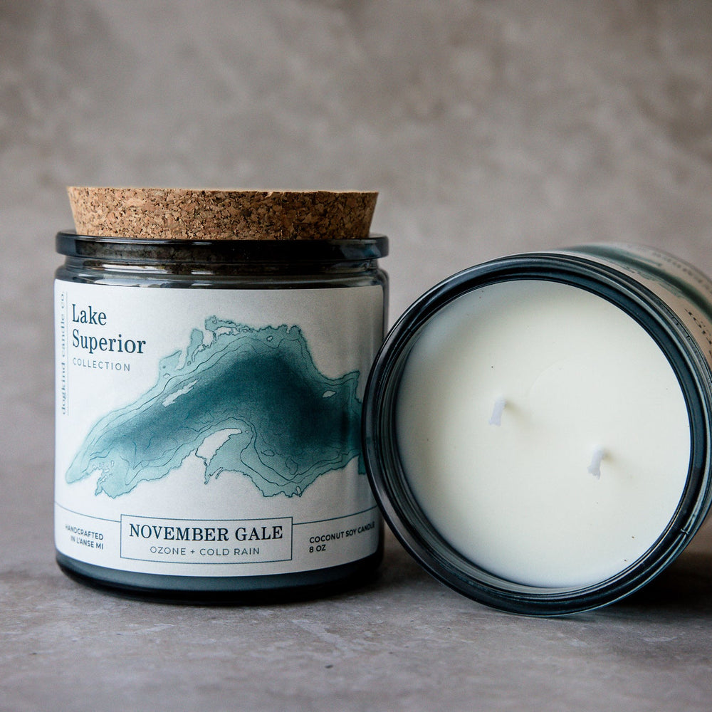Scented candle with cork lid and 'Lake Superior november gale ozone and cold rain' fragrance label on a gray background