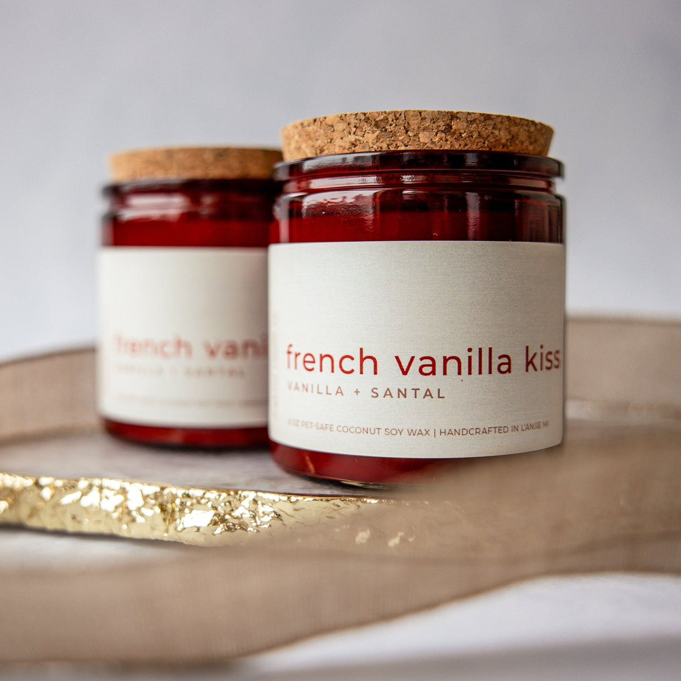 
                  
                    Two jars of 'French Vanilla Kisses' candle on a decorative tray with a white background
                  
                
