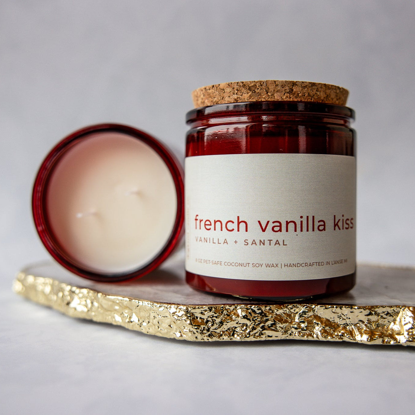 Candle labeled 'French Vanilla Kiss' on a gold coaster with a gray background