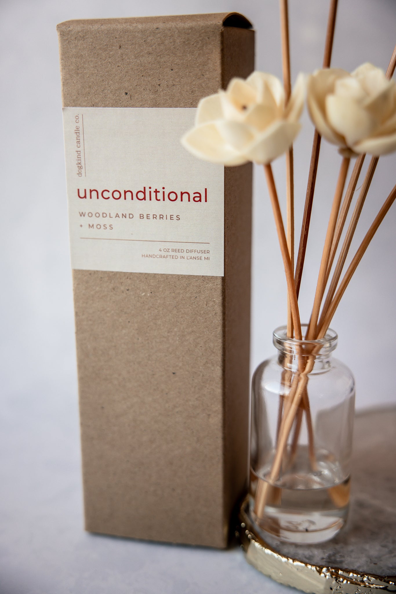 Unconditional valentine's day reed diffuser packaging with a glass diffuser bottle containing sticks on a light background