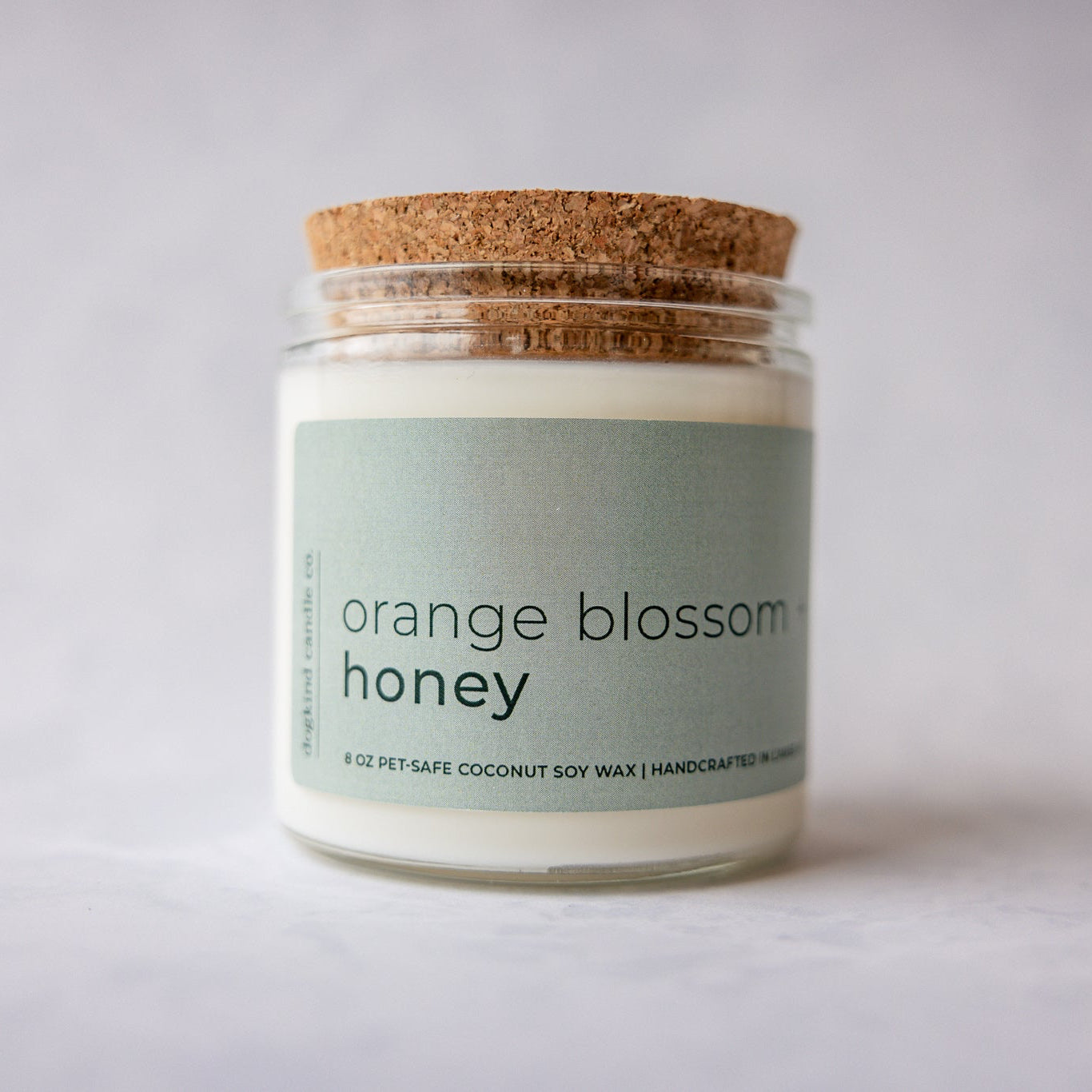 
                  
                    Candle jar labeled 'orange blossom honey' with a cork lid on a light background
                  
                