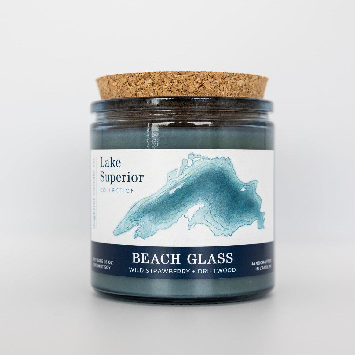 Candle jar with cork lid and 'Lake Superior' label on a white background