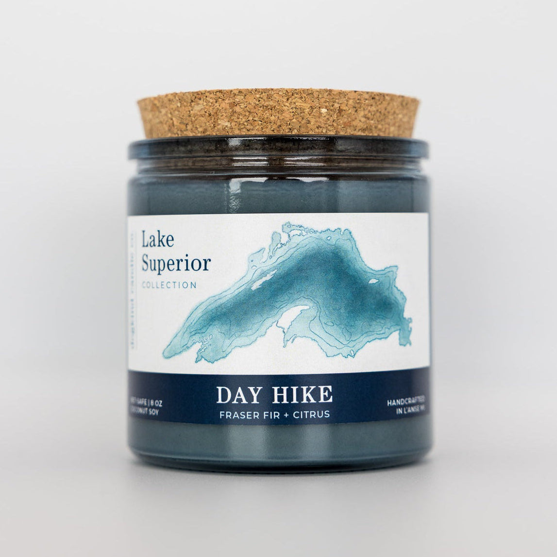 Candle jar labeled 'Lake Superior' with a cork lid on a white background