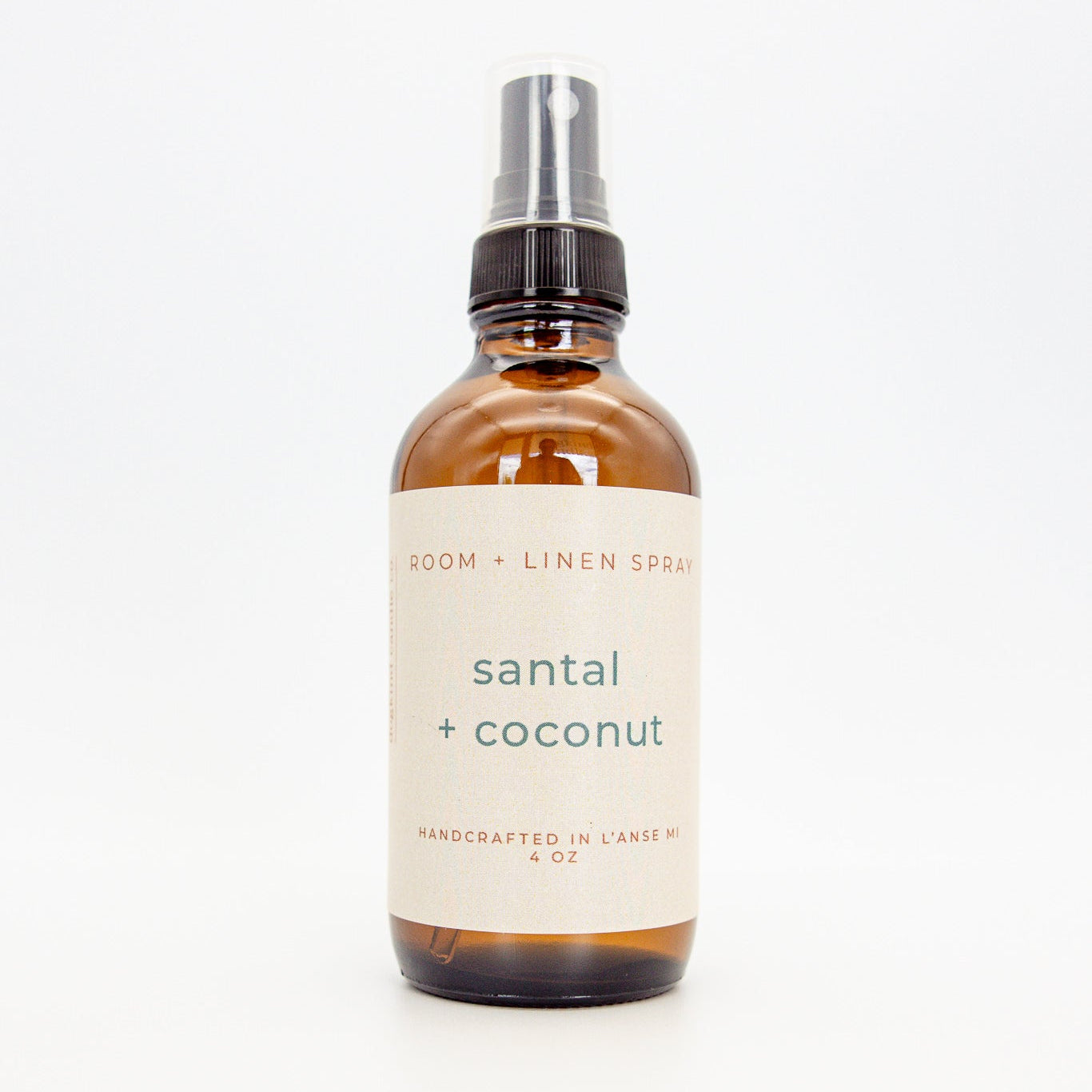 Bottle of 'santal + coconut' room and linen spray on a white background