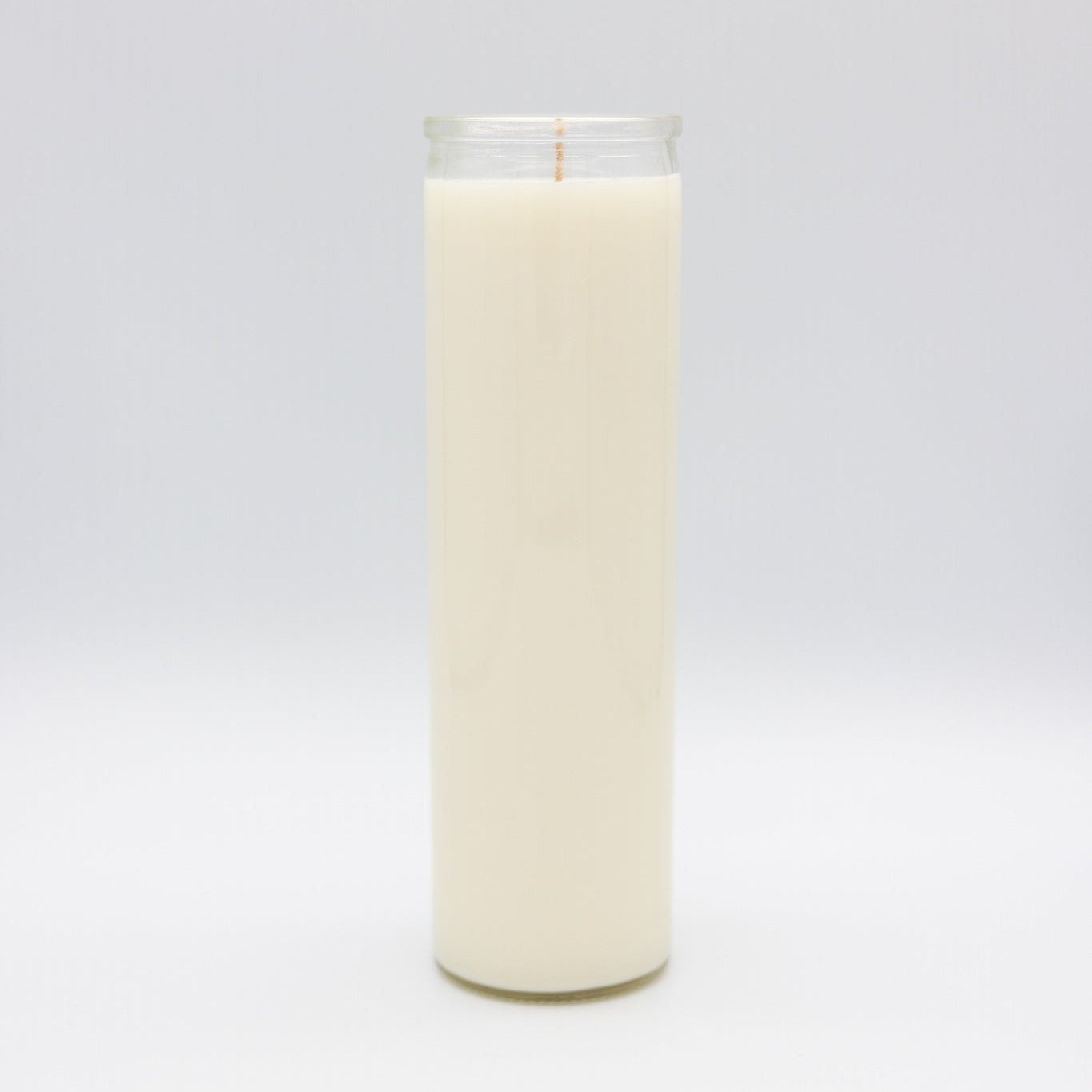 A white 7-day prayer candle filled with creamy off-white coconut soy wax, standing upright on a seamless light gray background.